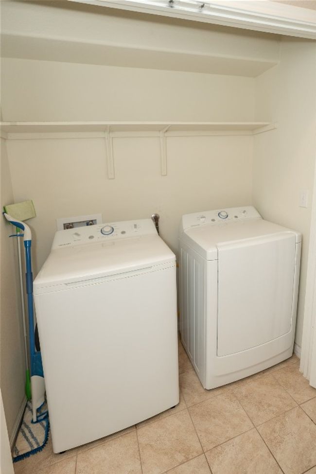 Laundry room featuring independent washer and dryer and light tile patterned floors | Image 5