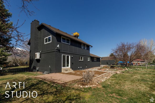 Back of property featuring a chimney, fence, entry steps, a patio, and a lawn | Image 37