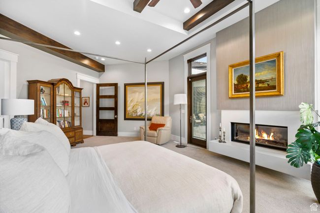 Bedroom featuring baseboards, recessed lighting, a glass covered fireplace, and light carpet | Image 36