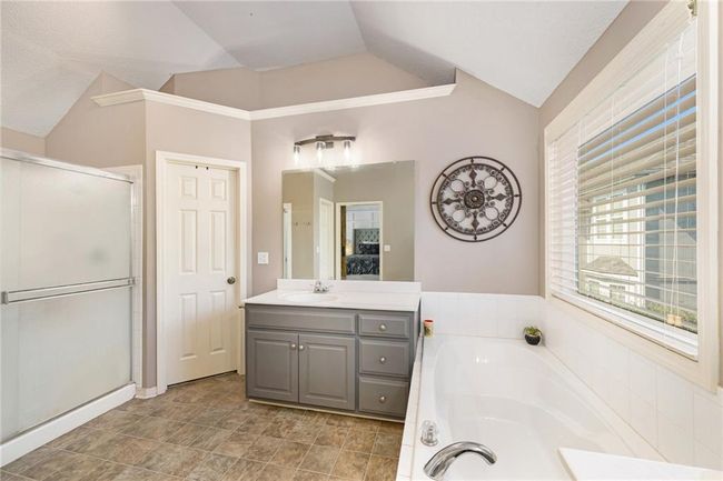 Ensuite bathroom featuring vaulted ceiling, a garden tub, a stall shower, and vanity | Image 32