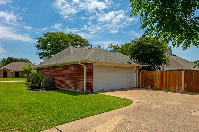 View of property exterior with brick siding, roof with shingles, an attached garage, central air condition unit, and concrete driveway | Image 28