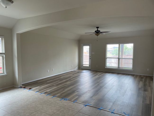 Empty room with vaulted ceiling, ceiling fan, and wood finished floors | Image 5