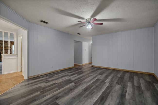 Unfurnished room featuring a ceiling fan, wood finished floors, and a textured ceiling | Image 15