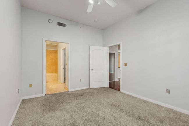 Unfurnished bedroom featuring carpet floors, connected bathroom, and ceiling fan | Image 19
