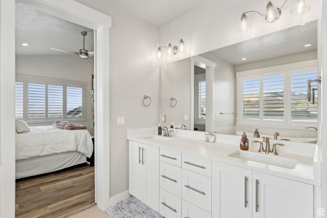 Bathroom with wood finished floors, ceiling fan, ensuite bath, and a sink | Image 16