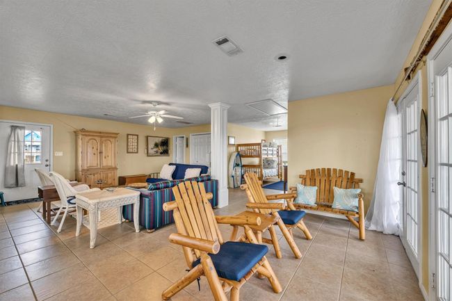 This view shows the open concept floor plan. Double French doors at the right provide access to the wrap around balcony. Ceramic tile flooring throughout is one of the interior features. | Image 4
