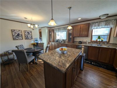 Kitchen with sink, a healthy amount of sunlight, a center island, and pendant lighting | Image 3