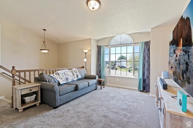 Living room featuring carpet floors, baseboards, and a vaulted ceiling | Image 4