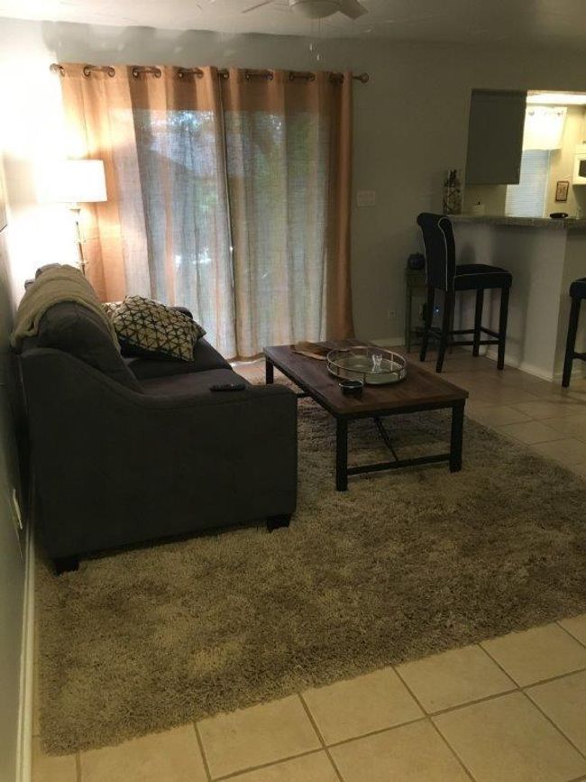 Living room with tile patterned flooring and ceiling fan | Image 4