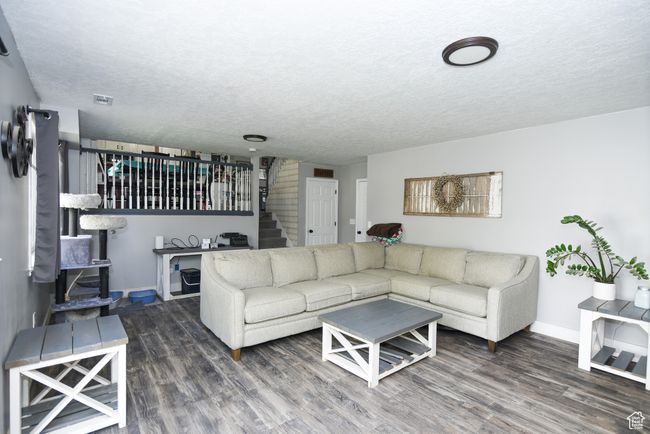 Living room featuring stairway, wood finished floors, and a textured ceiling | Image 20