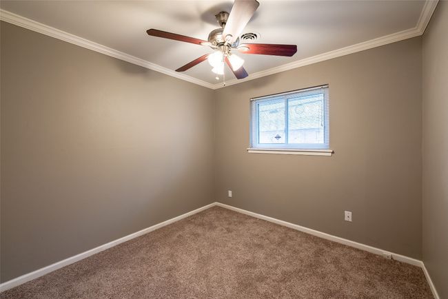 Carpeted spare room with crown molding and a ceiling fan | Image 23
