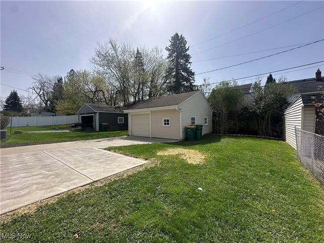 View of yard featuring driveway, an outdoor structure, fence, and a garage | Image 11