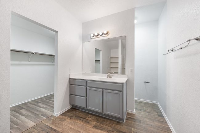 Bathroom with vanity, a spacious closet, and wood finished floors | Image 13