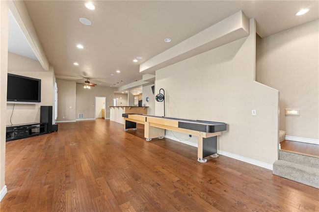 Recreation room featuring wood finished floors, recessed lighting, a ceiling fan, and baseboards | Image 35