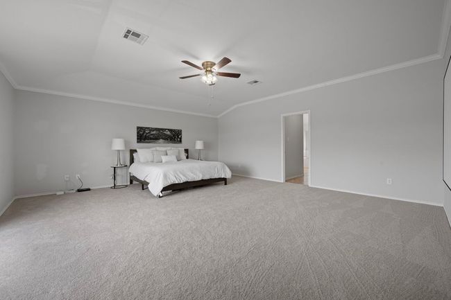 Carpeted bedroom with crown molding, baseboards, and ceiling fan | Image 17
