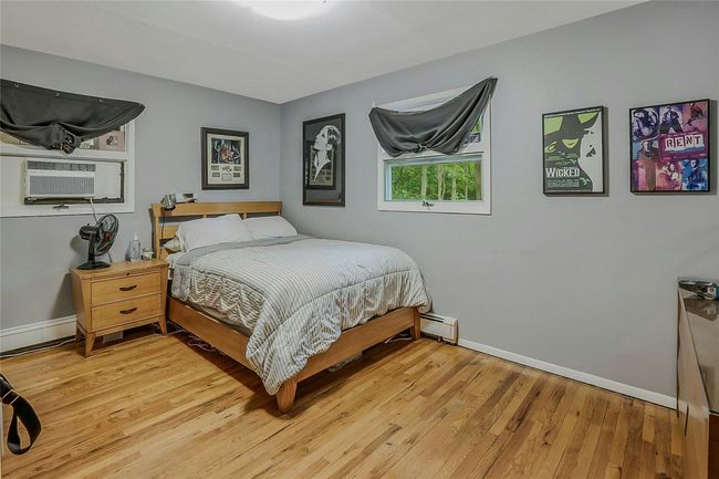 Bedroom with baseboards, light wood finished floors, a baseboard radiator, and cooling unit | Image 21