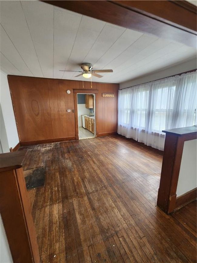 Unfurnished living room with baseboards, ceiling fan, and wood-type flooring | Image 11