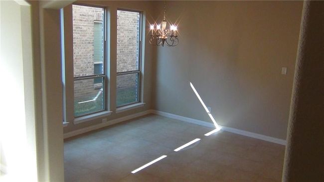 Unfurnished dining area featuring a chandelier, baseboards, and tile patterned floors | Image 14