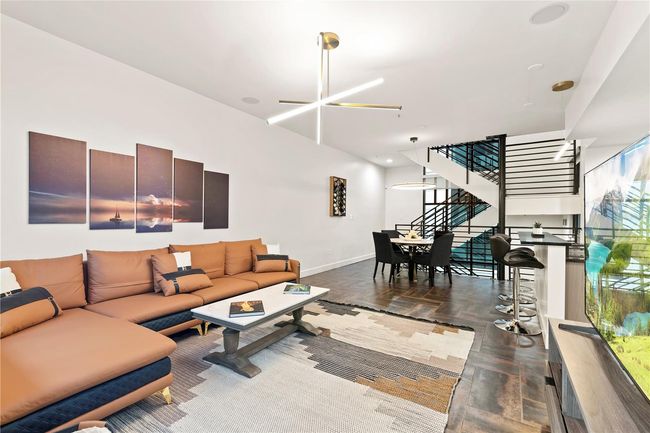 LIVING ROOM WITH CONTEMPORARY LIGHTING FIXTURE IN FOREGROUND WITH DINING AREA IN BACKGROUND | Image 31