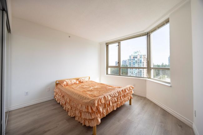 Bedroom featuring wood finished floors and a view of city | Image 12