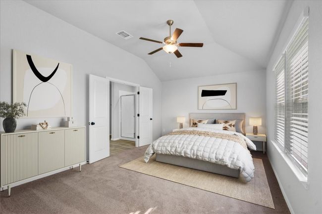 Carpeted bedroom with lofted ceiling, a ceiling fan, multiple windows, and visible vents | Image 14