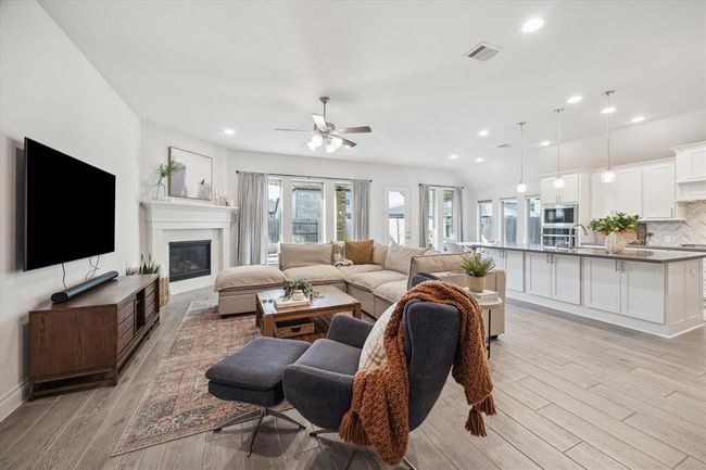 Seamlessly connected to the kitchen, the living room showcases an open-concept layout that also includes the breakfast area, perfectly designed to foster effortless interaction and convenience, making it an ideal setting for both lively gatherings and intimate family moments. | Image 10