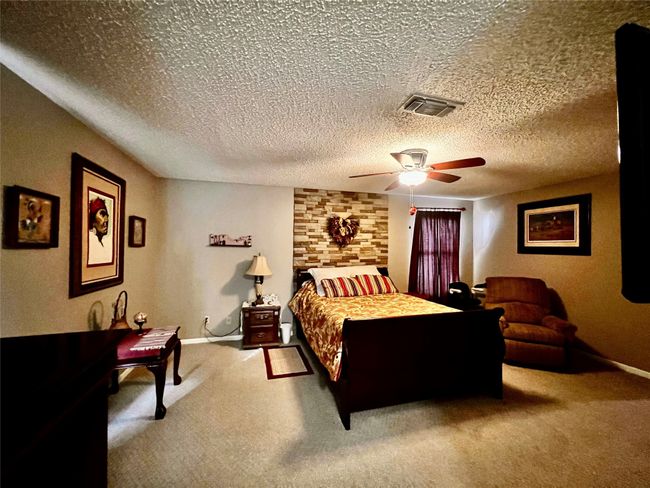 Bedroom with carpet flooring, a textured ceiling, and ceiling fan | Image 11