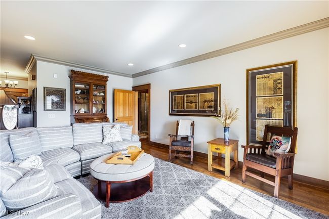 Living room featuring a chandelier, baseboards, wood finished floors, and recessed lighting | Image 22