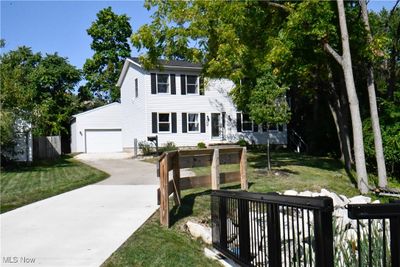 Colonial inspired home with a garage and a front lawn | Image 1