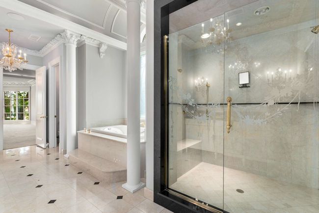 Bathroom featuring a garden tub, crown molding, tile patterned flooring, a chandelier, and ornate columns | Image 17