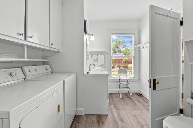 Laundry room with washing machine and clothes dryer and light wood-type flooring | Image 19