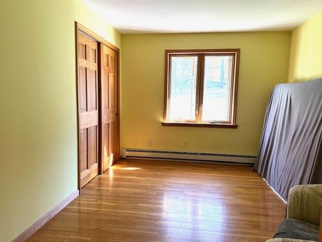 Unfurnished bedroom featuring a closet, a baseboard heating unit, and light wood-type flooring | Image 18