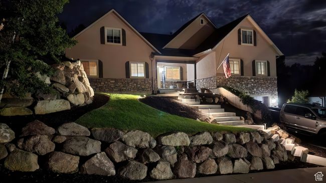 Front of house at twilight featuring stucco siding and stone siding | Image 4