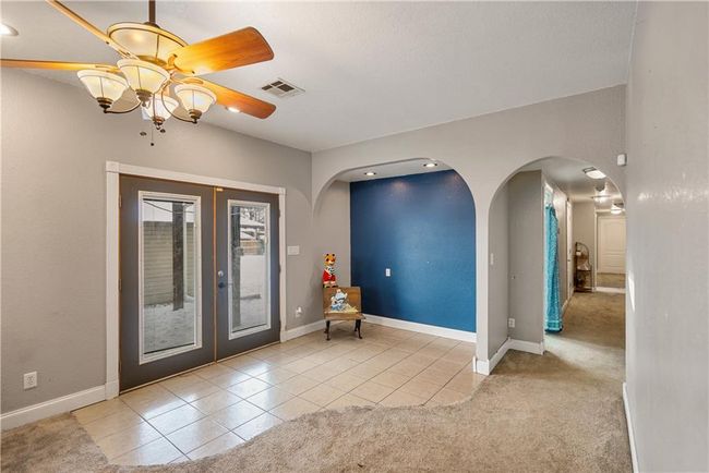 Foyer entrance with french doors, ceiling fan, and light carpet | Image 23
