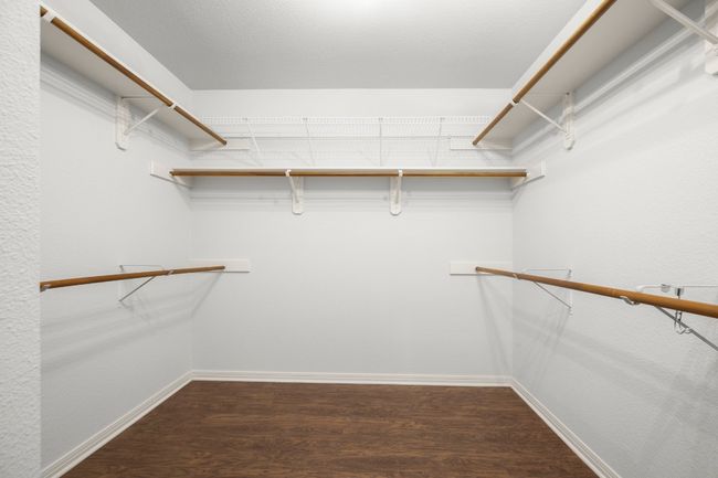 Walk in closet featuring dark wood finished floors | Image 21