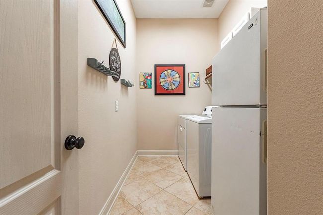 Large tiled utility room in house. | Image 44
