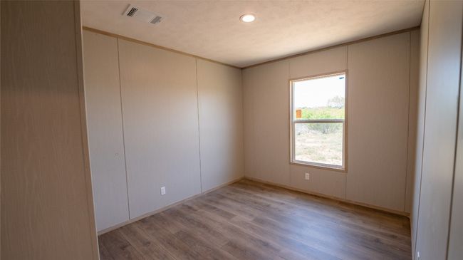 Unfurnished room featuring light wood finished floors, crown molding, and a decorative wall | Image 18