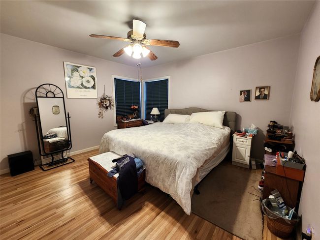 Bedroom with baseboards, light wood-style flooring, and a ceiling fan | Image 23