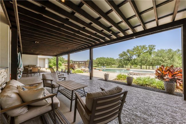 View of patio featuring an outdoor hangout area, outdoor dining space, and a pool with connected hot tub | Image 13