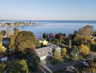 Aerial photo showing the house and surrounding property, as well as proximity to the beach. | Image 1