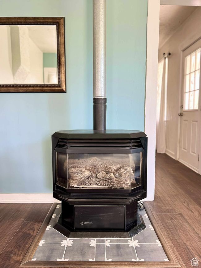 Details with wood finished floors, a wood stove, and baseboards | Image 10