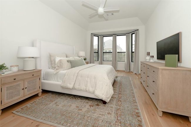 Bright primary bedroom featuring an elegant bay window. | Image 20