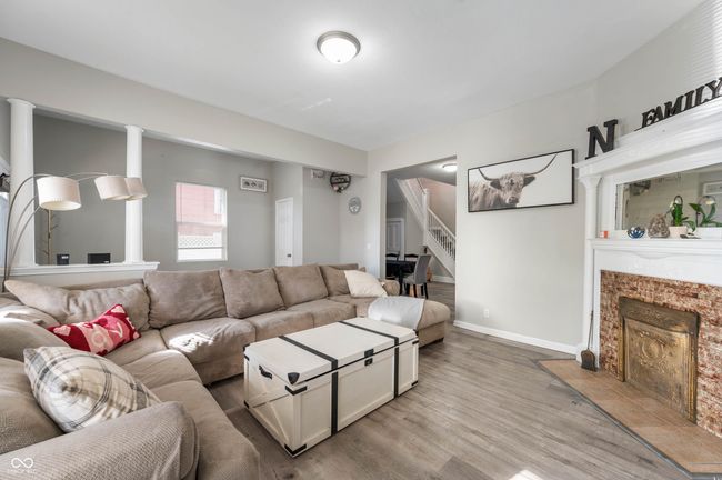living room with light wood-style floors, a tile fireplace, baseboards, and stairs | Image 5