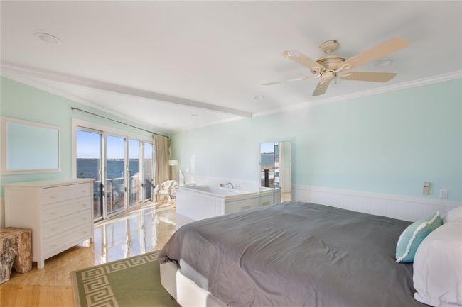 Bedroom featuring wainscoting, crown molding, light wood finished floors, and ceiling fan | Image 10