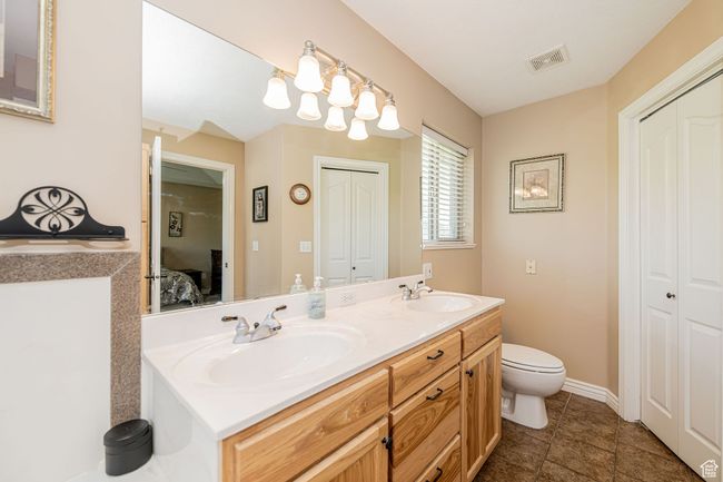 Ensuite bathroom featuring a closet, double vanity, and tile patterned floors | Image 18