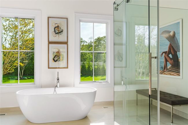 Full bath featuring healthy amount of natural light, a soaking tub, and a shower with door | Image 28
