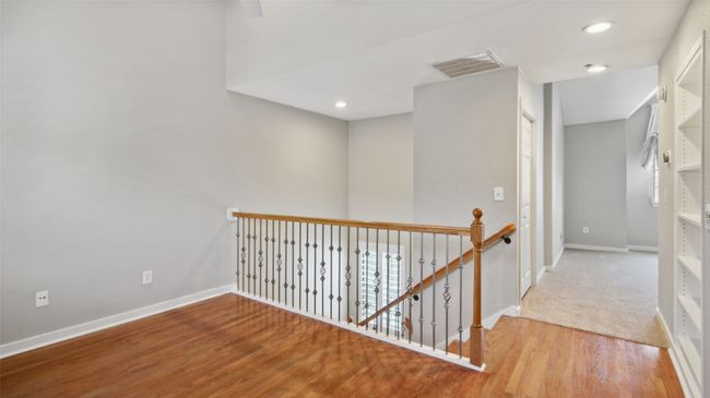 Corridor featuring an upstairs landing, baseboards, wood finished floors, and recessed lighting | Image 15