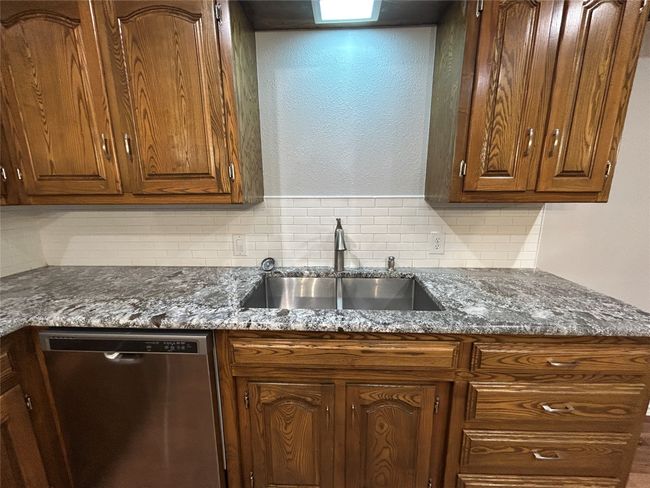 Kitchen with dishwasher, decorative backsplash, and dark stone countertops | Image 19
