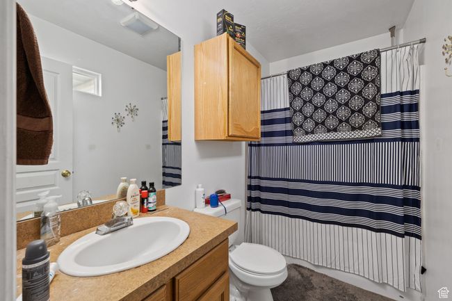 Bathroom with a shower with shower curtain, toilet, and vanity | Image 46