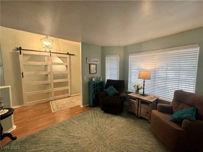Sitting room featuring a barn door and wood finished floors | Image 11